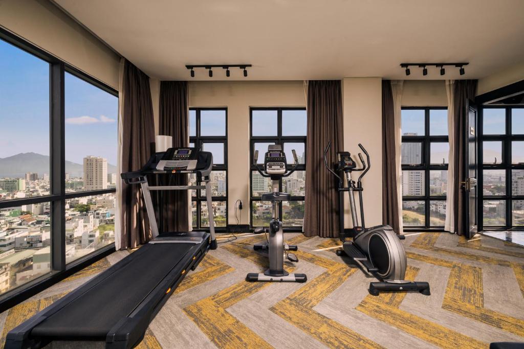 A cardio gym overlooking the city through a wall of tall windows.