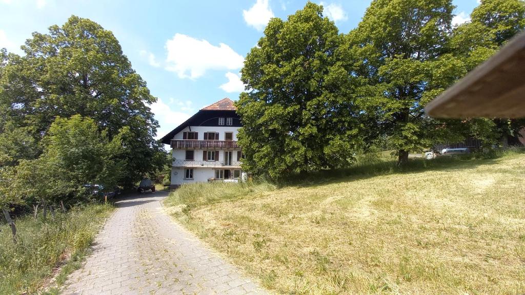 eine unbefestigte Straße vor einem weißen Gebäude in der Unterkunft La Belle Etoile - Bauernhof in mitten der Natur 