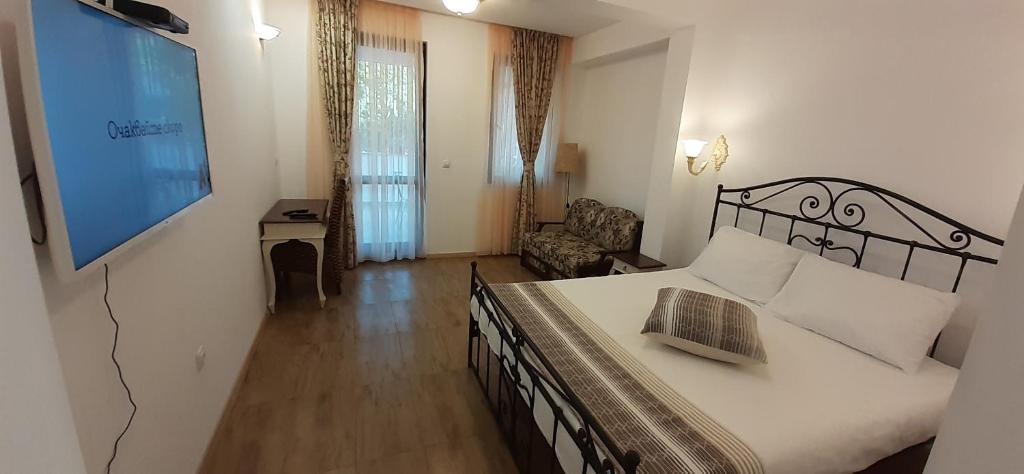 a bedroom with a large bed and a living room at Family Hotel Rai in Shumen