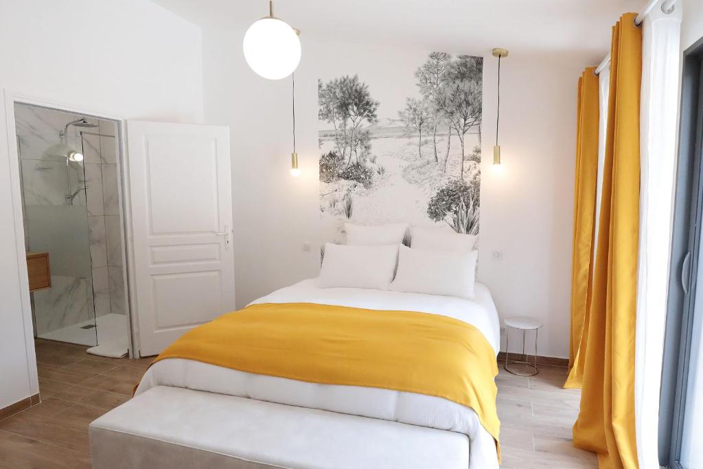 1 dormitorio con 1 cama con manta amarilla en Pierres Blanches Guérande - Maison d'hôtes en Guérande