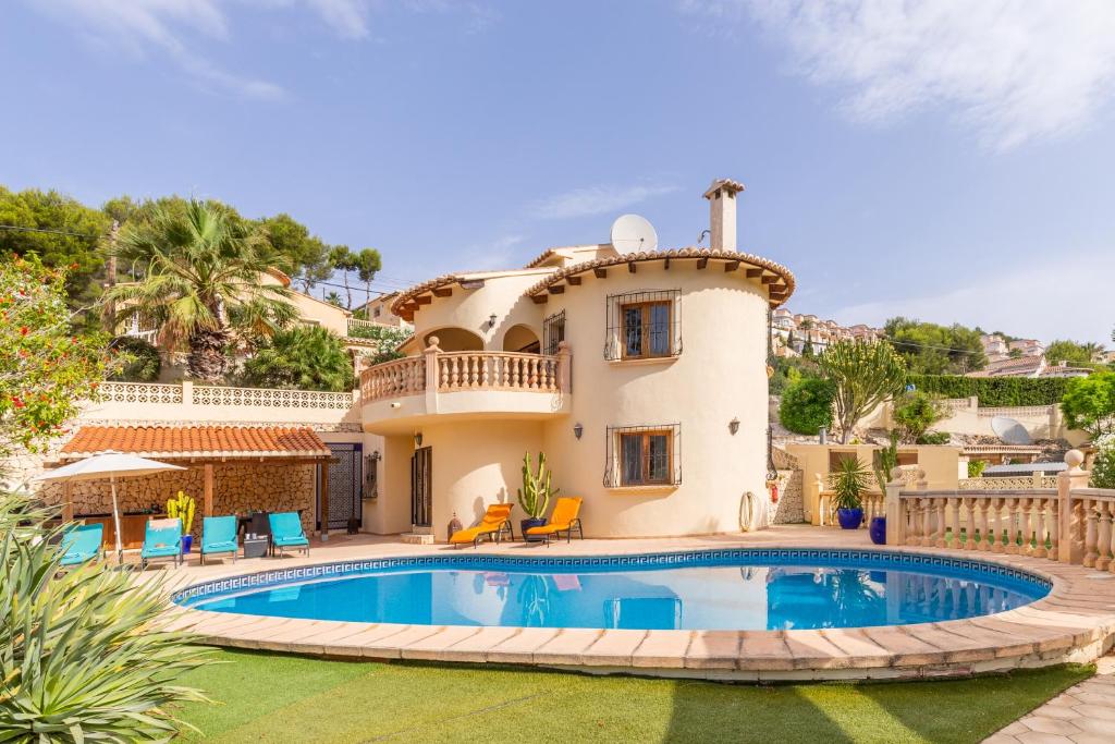 Villa con piscina frente a una casa en Villa Rafael en Cumbre del Sol