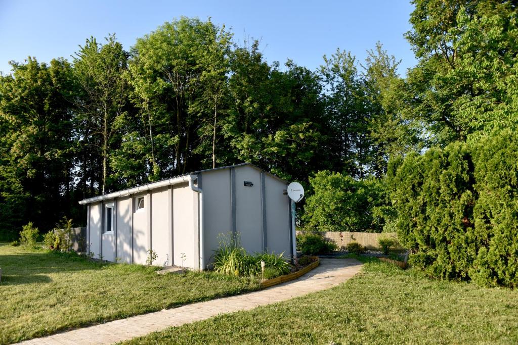 un pequeño edificio blanco en un campo con árboles en Gîte Nature et détente en Aubréville