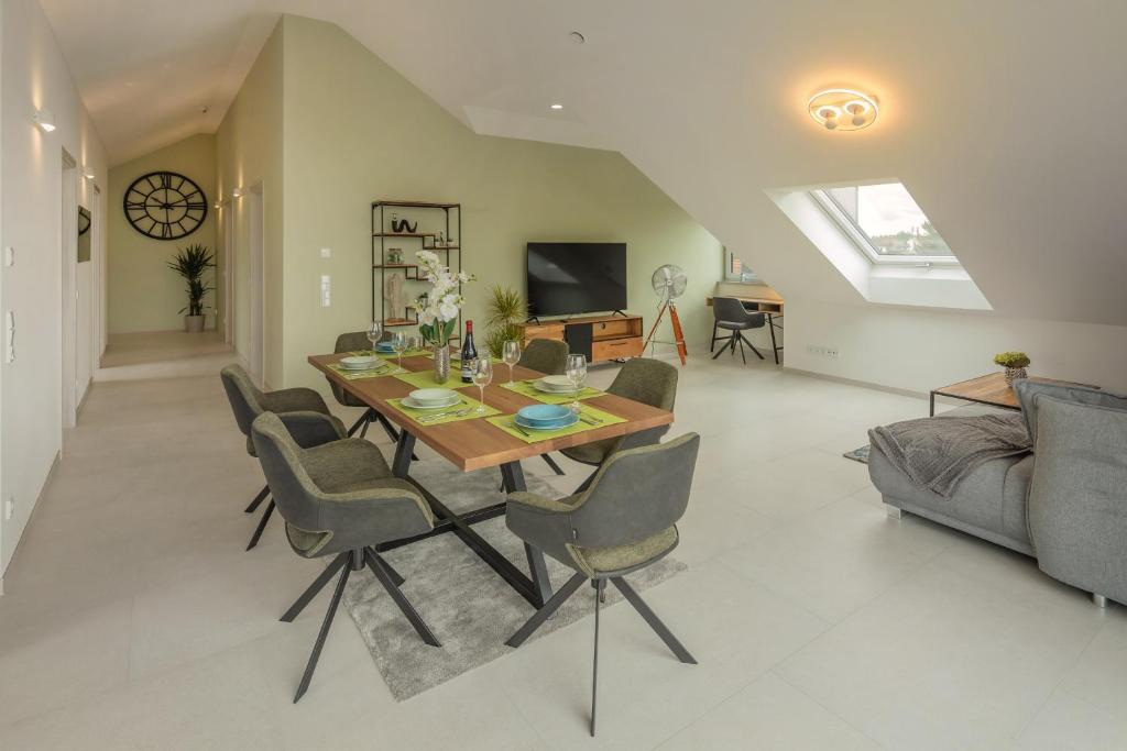 a dining room and living room with a table and chairs at SweetHome - Poing Apartments in Poing