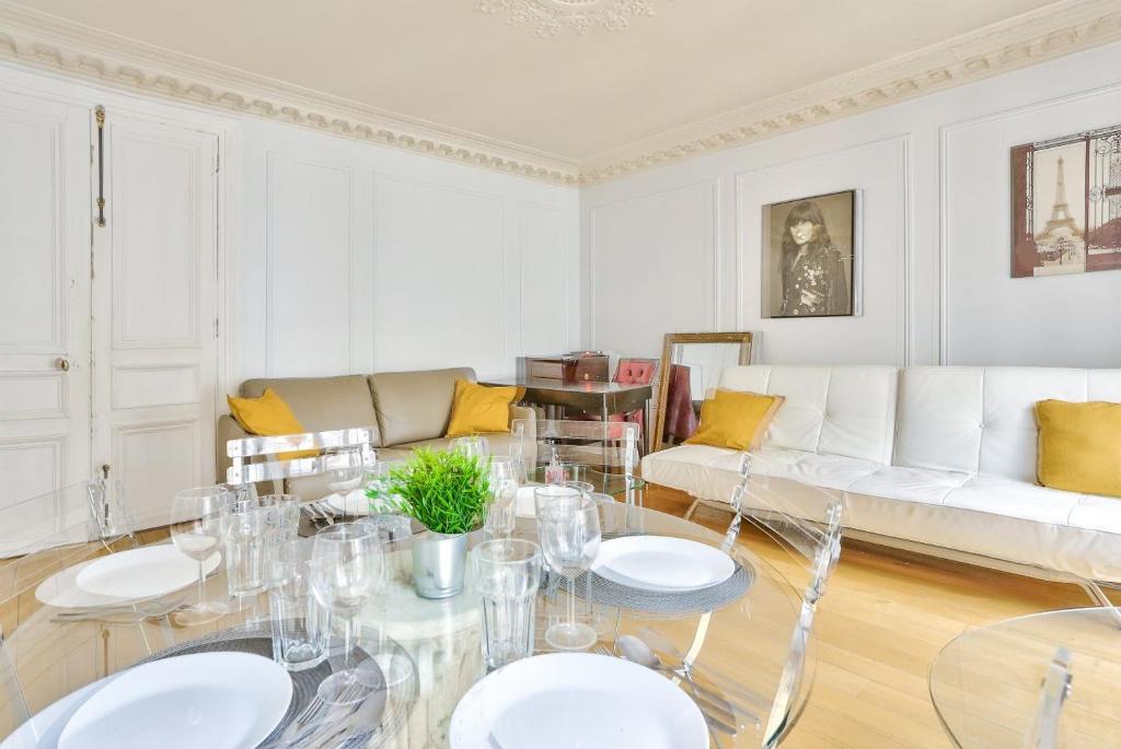 ein Wohnzimmer mit einem Tisch und einem Sofa in der Unterkunft Appartement Quartier Champs-Élysées 3 in Paris