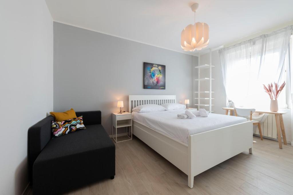 a bedroom with a white bed and a black chair at Casa Maglò camere in Verona