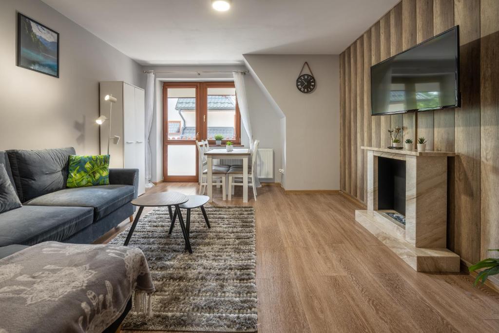 a living room with a couch and a fireplace at RentPlanet - Apartament Antałówka in Zakopane
