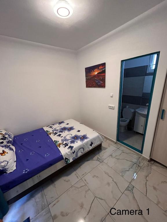 a bedroom with a bed in a room with a mirror at Locuință privată la mare in Schitul
