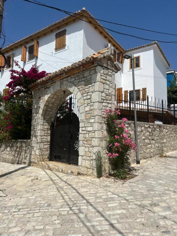 una casa con un arco de piedra frente a un edificio en Old Town Hotel Dhermi, en Dhërmi