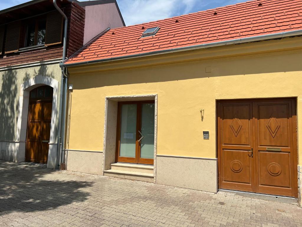um edifício com duas portas e um telhado vermelho em Aradi 6 Apartman Pécs em Pécs