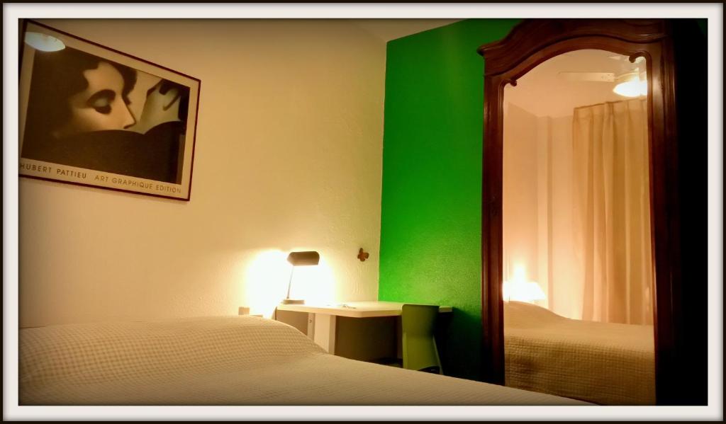 a bedroom with a green wall and a bed and a mirror at Sonia's Homestay in Rio de Janeiro