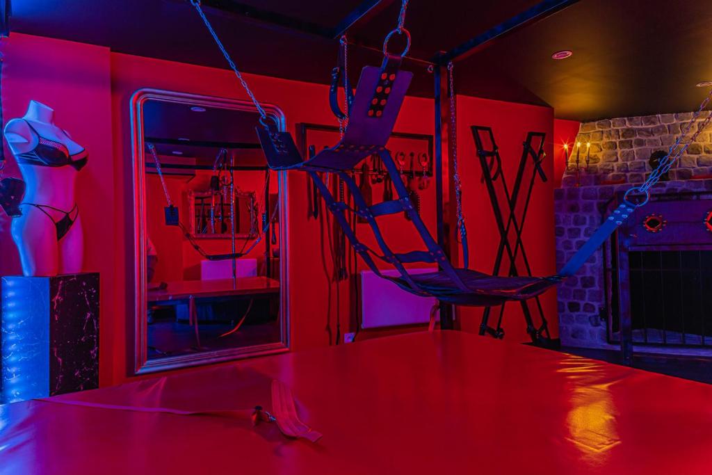 a room with two chairs in a room with red lights at Playroom XXL Loft LOVE Room avec Espace spa Terrasse vue sur les toits Salle de jeux pour adultes Libourne centre 10 min de St Emilion Proche Bordeaux in Libourne