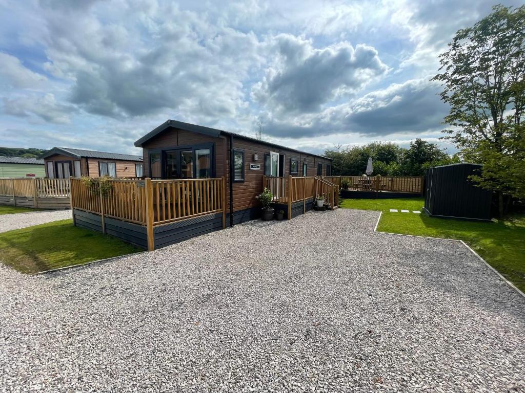 a cabin with a deck and a house at 16 Lake View, Pendle View Holiday Park, Clitheroe in Clitheroe
