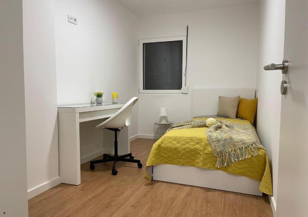 萊里亞的住宿－Casa das 3 Bicas，一间卧室配有一张床、一张书桌和一个窗户。
