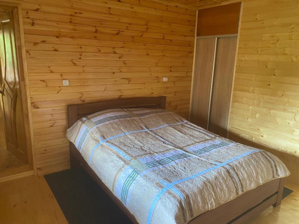 een slaapkamer met een bed in een blokhut bij Гостинний двір у дядька Івана in Mizhhirya