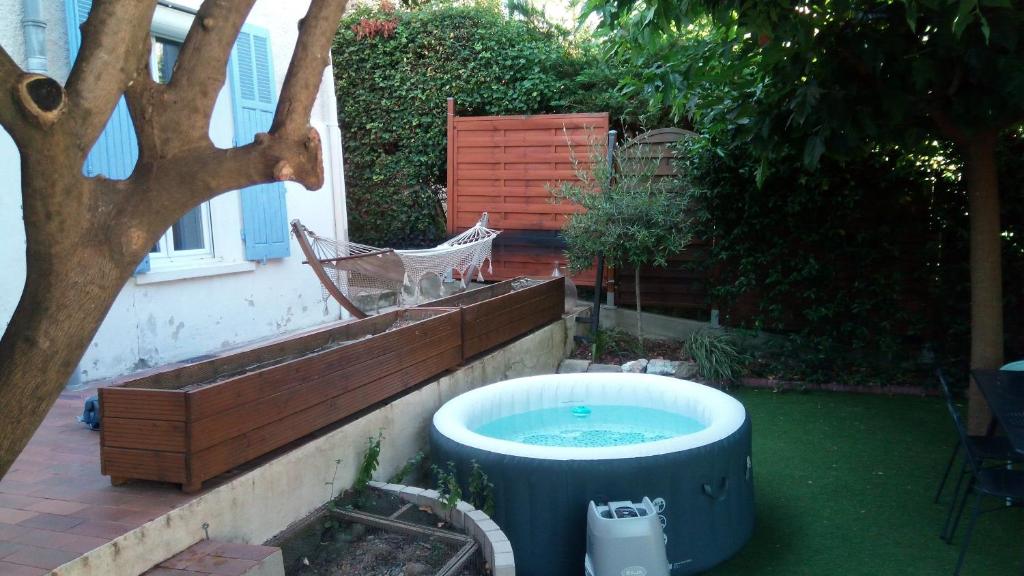 - un bain à remous dans une cour à côté d'un arbre dans l'établissement Jolie maison de ville avec jardin arboré, à La Seyne-sur-Mer