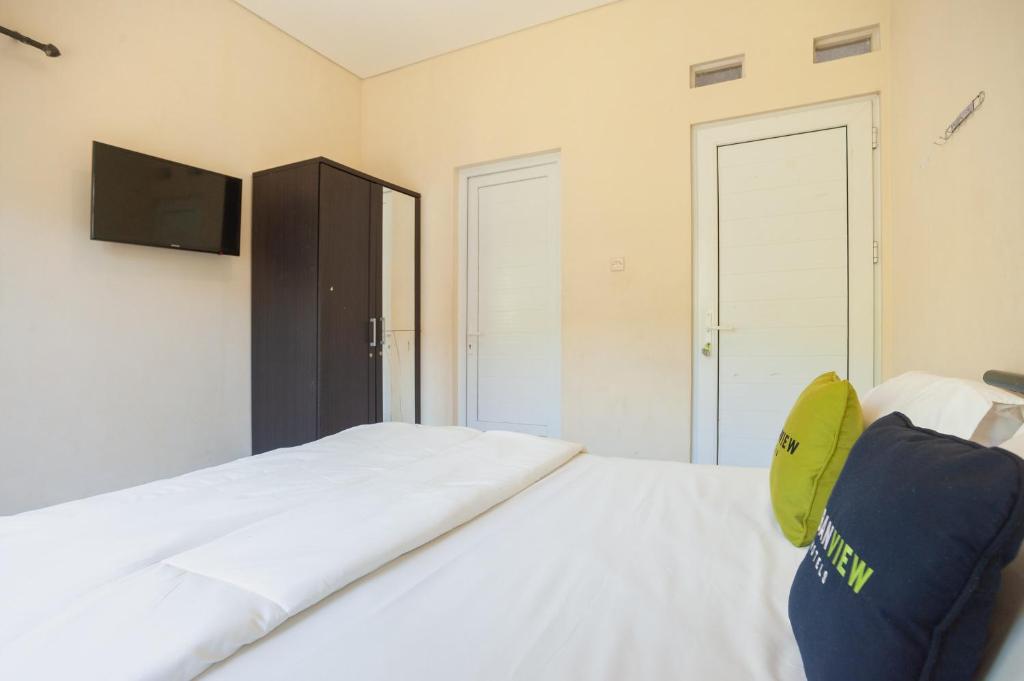 Postel nebo postele na pokoji v ubytování Urbanview Resort Adang Zecky Cisarua Puncak by RedDoorz