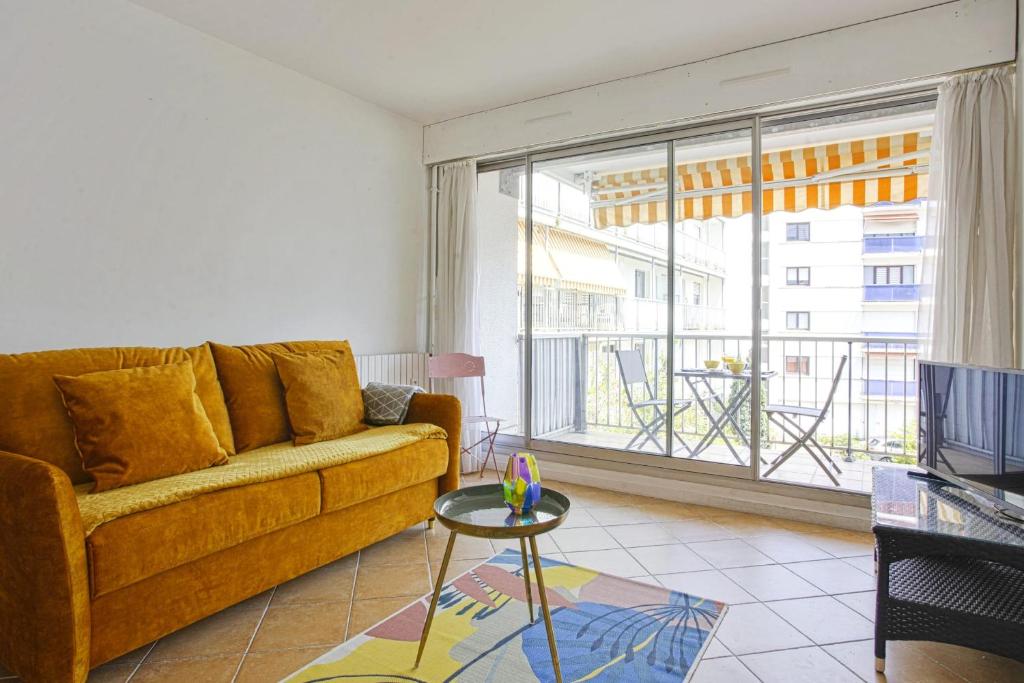 un salon avec un canapé et une grande fenêtre dans l'établissement Appartement Herta - Welkeys, à Biarritz