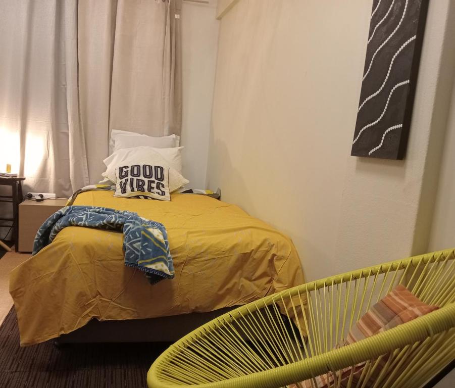 sypialnia z łóżkiem i żółtym krzesłem w obiekcie City Stadium 5 minutes Walk w mieście Townsville