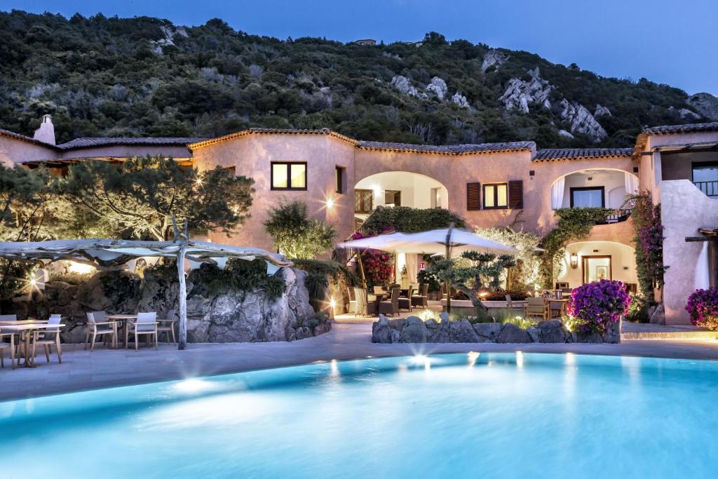 a hotel with a swimming pool in front of a building at Relais Villa Carola in Porto Cervo