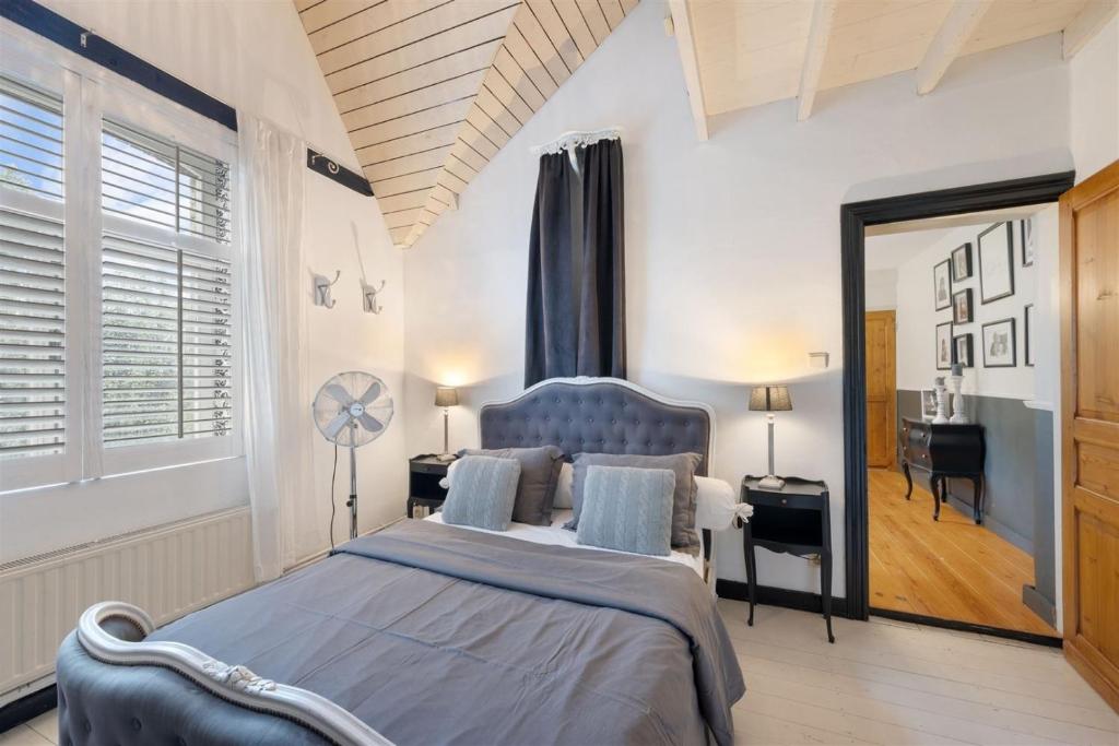 1 dormitorio con 1 cama grande y espejo en BNB 't Oud Schooltje, en Stavelhoekje