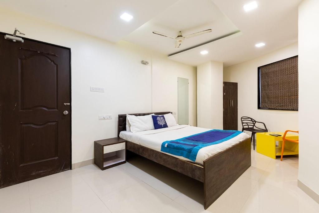 a bedroom with a bed and a black door at Hotel Girgoan Palace in Mumbai