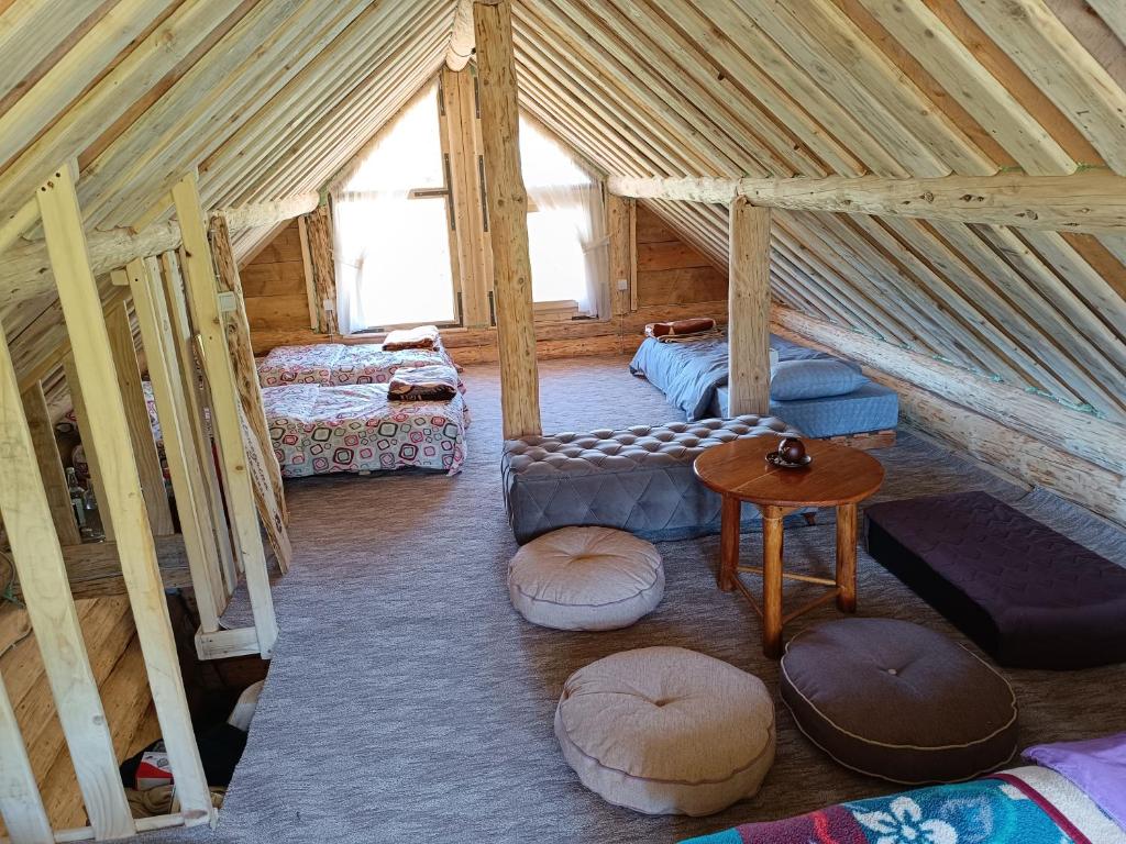 a attic room with two beds and a table at Komovi - Montenegrina Mountain house in Kolašin
