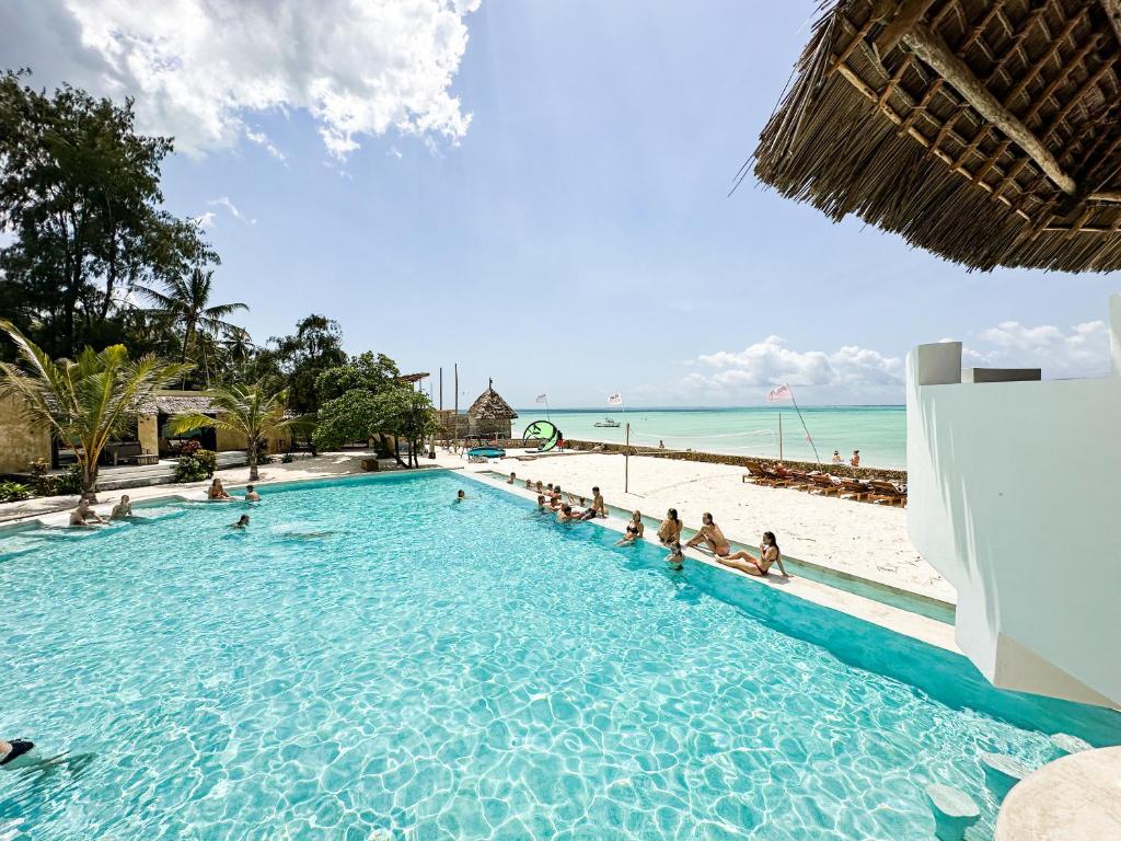 a large swimming pool next to a beach at Jambo Beach Hotel Paje in Paje
