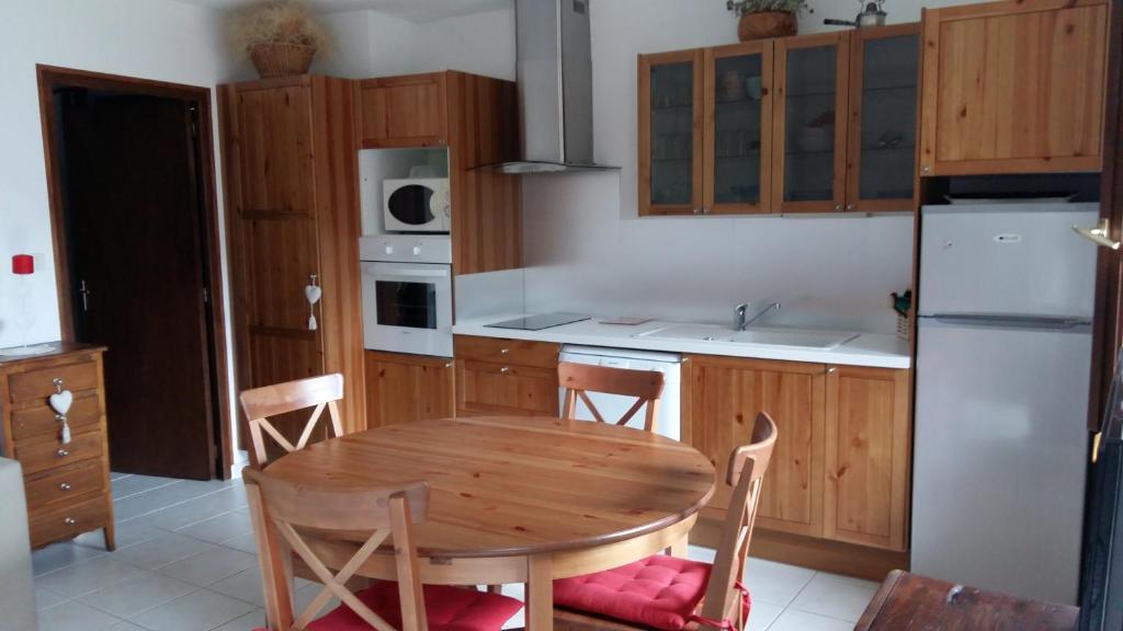 una cocina con mesa de madera y sillas. en Appartement chalet 4 pers 45m2 Puy Saint Vincent en Puy-Saint-Vincent