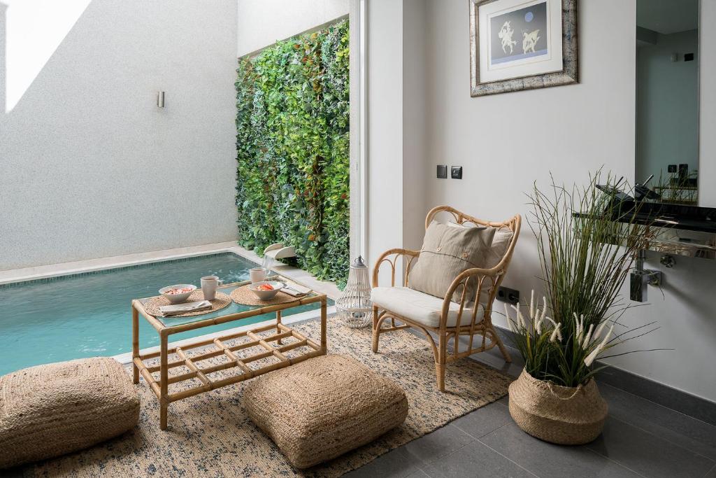 uma sala de estar com uma mesa, uma cadeira e água em Downtown Pool House em Faro