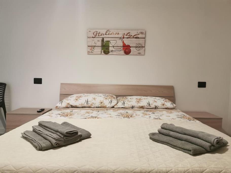 1 dormitorio con 1 cama con toallas en Appartamento - La Bella Italia, en Canelli