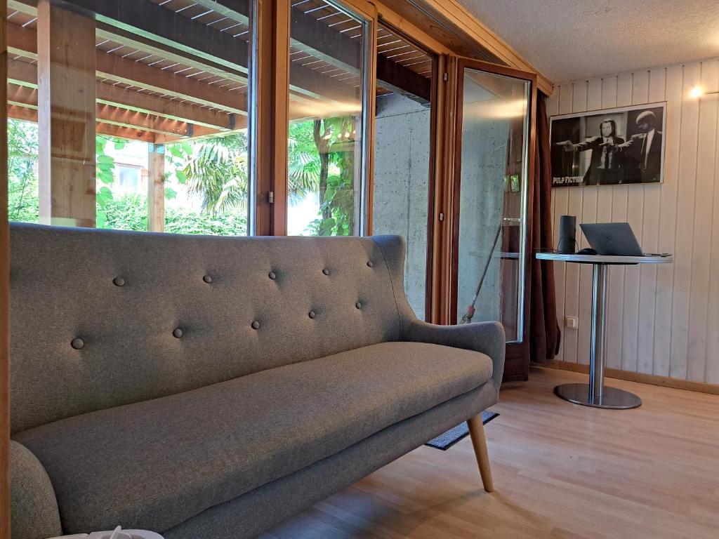 un divano in soggiorno con un computer portatile sul tavolo di Studio indépendant en résidence avec extérieur a Portalban- Dessous