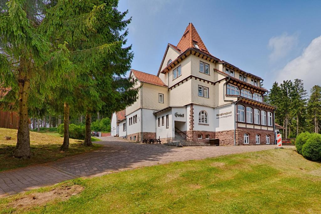 a large house with a tower on top of a yard at Hotel Spießberghaus in Friedrichroda