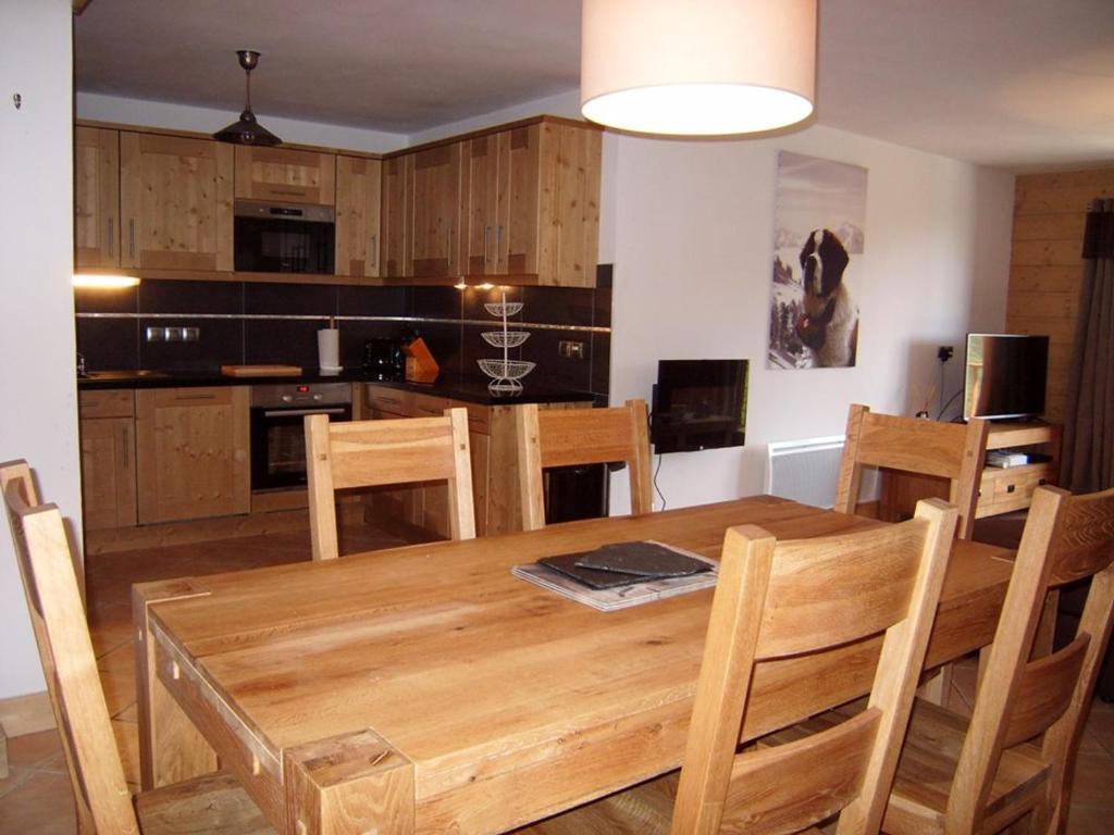 kuchnia i jadalnia z drewnianym stołem i krzesłami w obiekcie Appartement Crest-Voland, 5 pièces, 8 personnes - FR-1-733-123 w mieście Crest-Voland