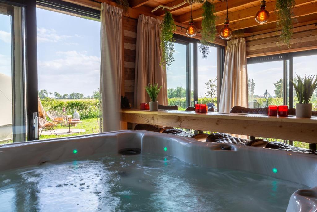einen Whirlpool in einem Zimmer mit Fenstern in der Unterkunft De luxe overkapping in Middelburg