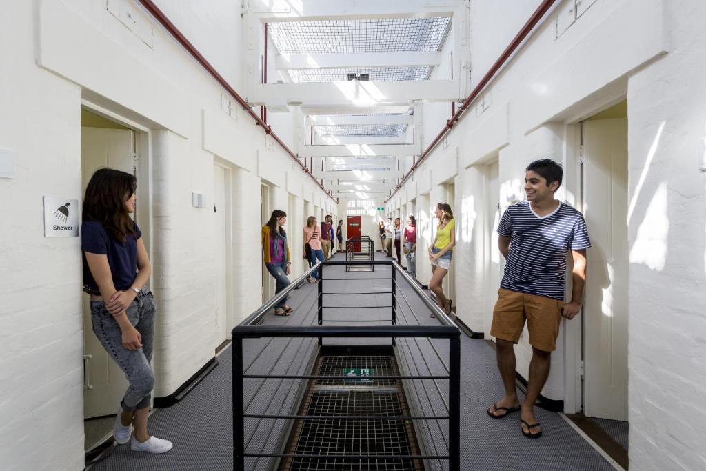 ludzie stojący w korytarzu budynku w obiekcie YHA Fremantle Prison w mieście Fremantle