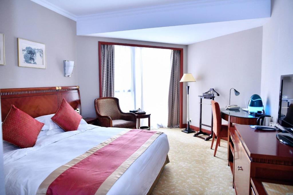 a hotel room with a bed and a desk and a computer at Shenzhen Best Western Felicity Hotel, Luohu Railway Station in Shenzhen