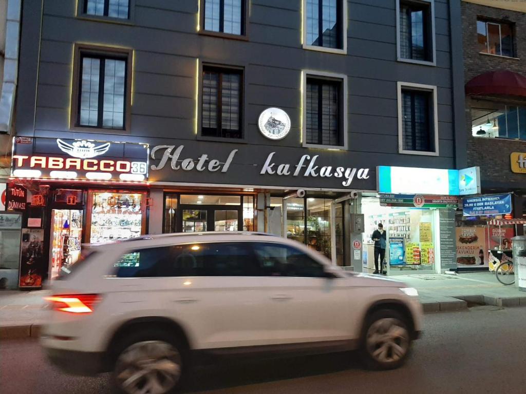 a white car driving down a street in front of a building at Hotel Kafkasya in Kars