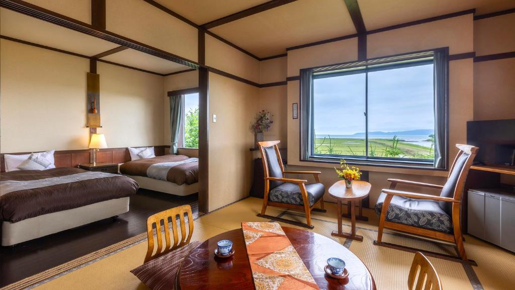 una camera d'albergo con un letto e una finestra di Kagariya a Abashiri