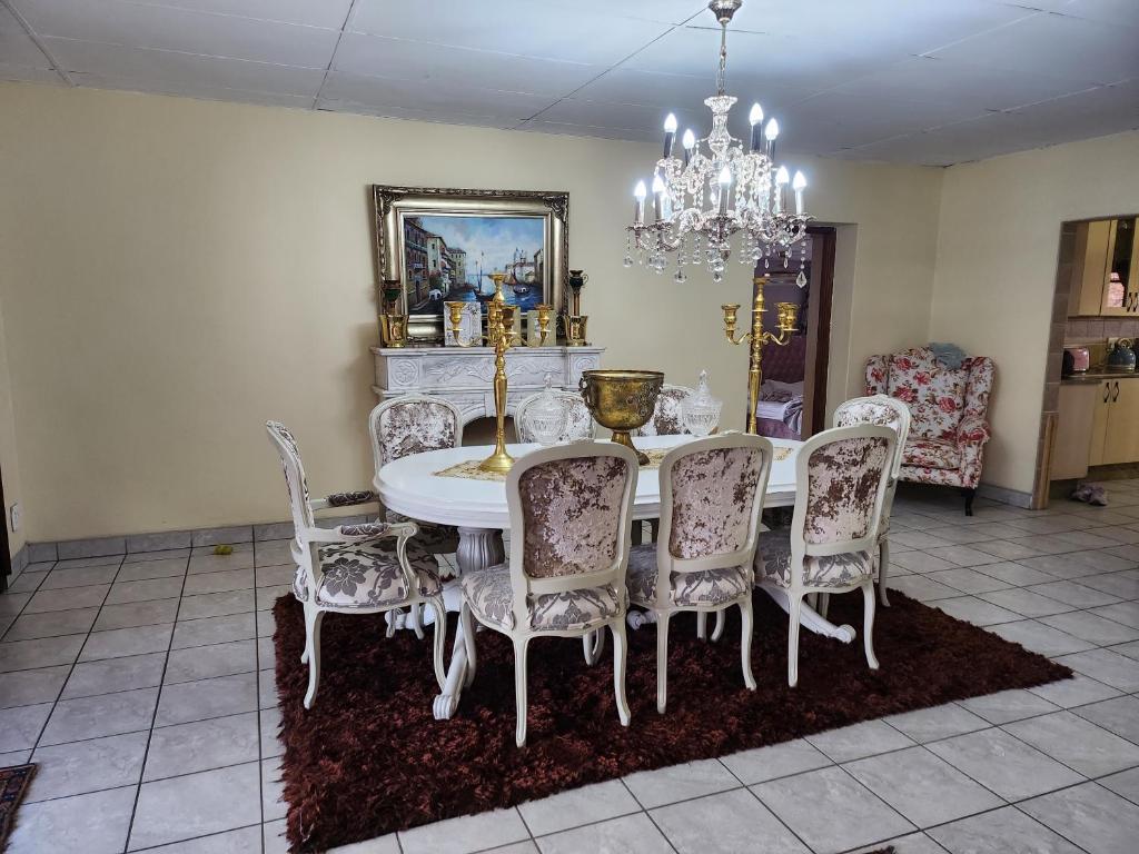 a dining room with a white table and chairs at Chateau De Vie in Krugersdorp
