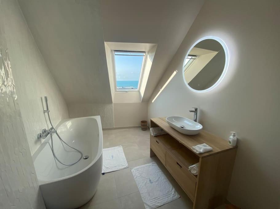 une salle de bain avec une baignoire, un lavabo et un miroir dans l'établissement Granville / Maison entièrement rénovée à 100 m des plages, à Granville
