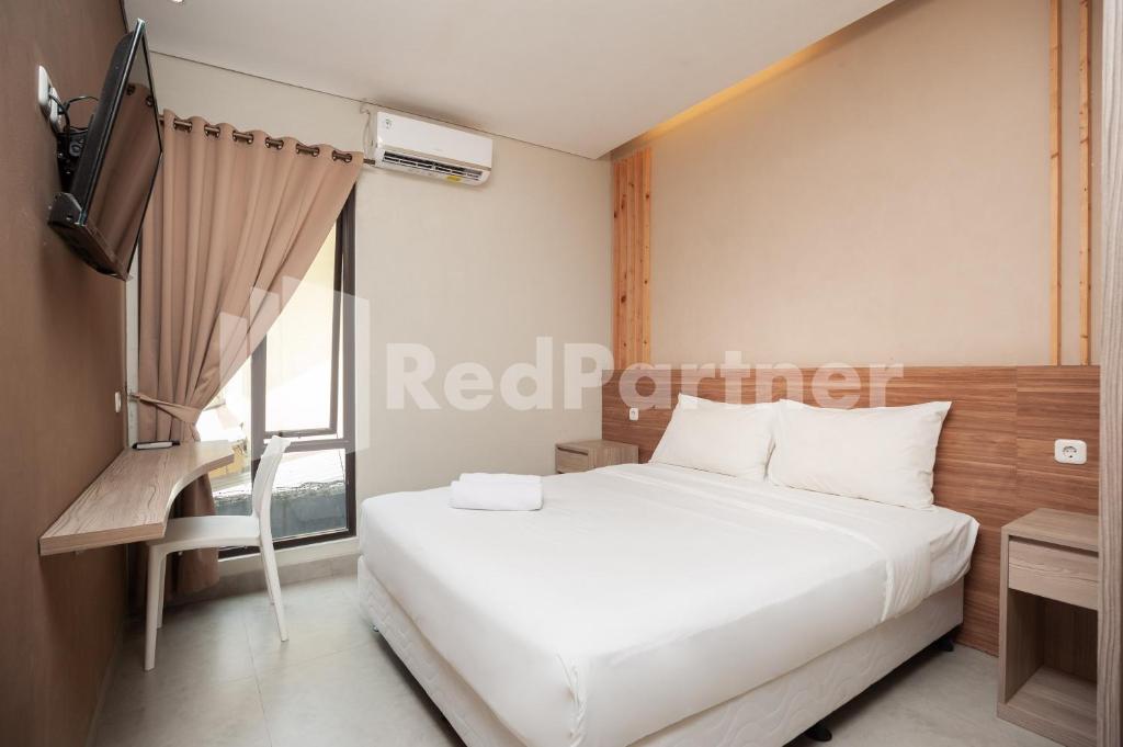 a bedroom with a white bed and a television at Urbanview Syariah Caseira Citra Raya in Pabuaran