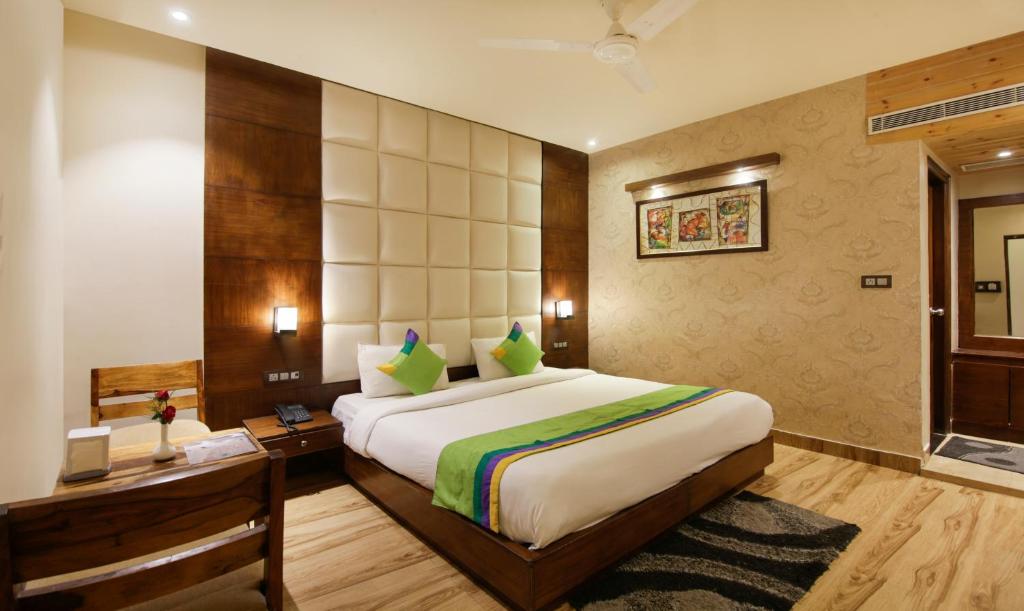 una camera con un grande letto e una scrivania di Treebo Trend Punjabi Nature Residency a Faridabad