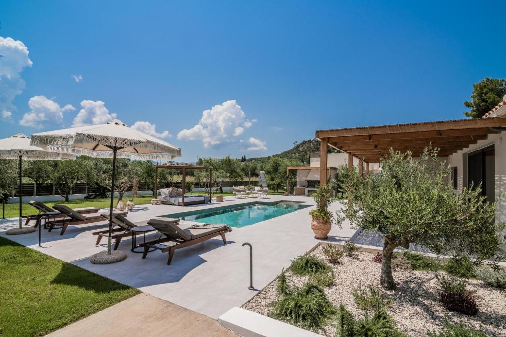 a backyard with a swimming pool and a house at Tsilivi Pandessia Villa in Tsilivi