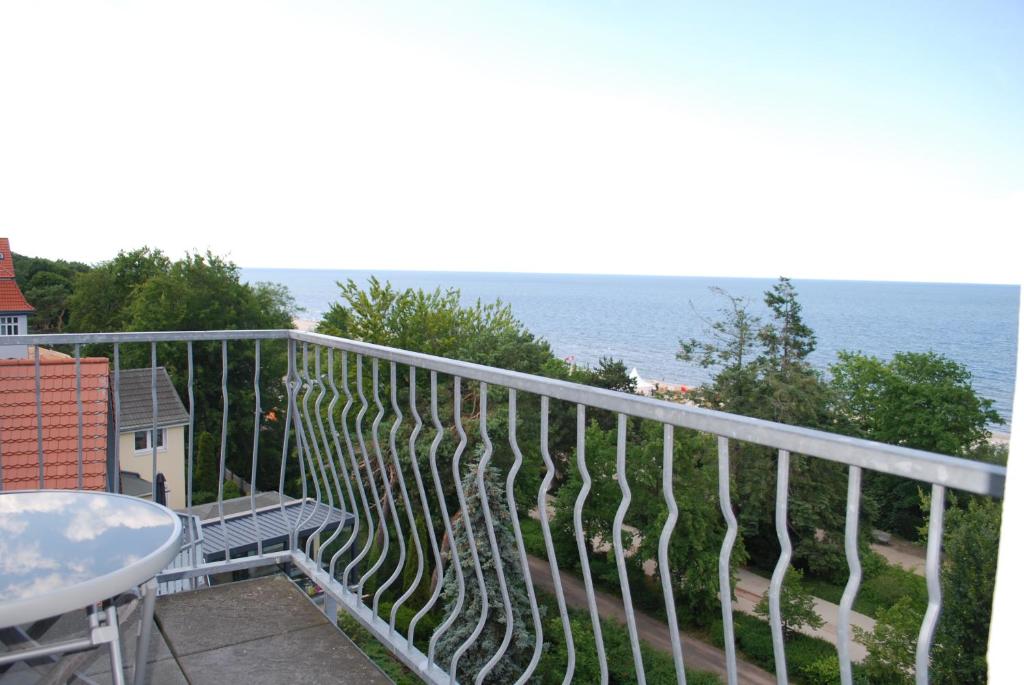 balcón con mesa y vistas al océano en Haus-am-Kliff-App-07, en Heringsdorf