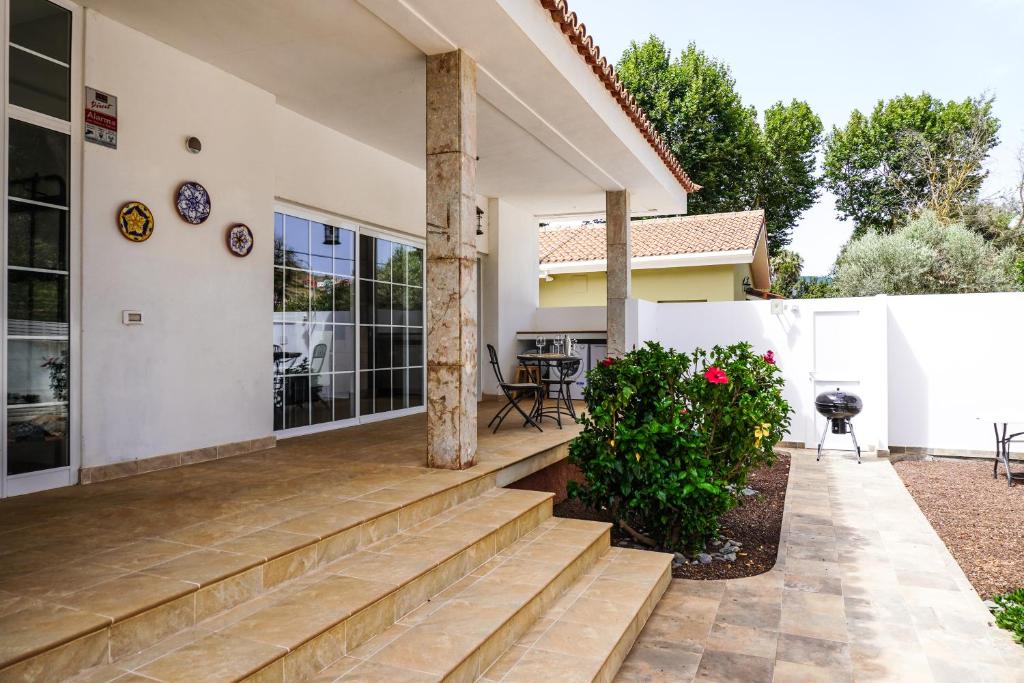 a home with a porch with stairs leading to a patio at Casa Las Peras, La Laguna in Las Lagunas