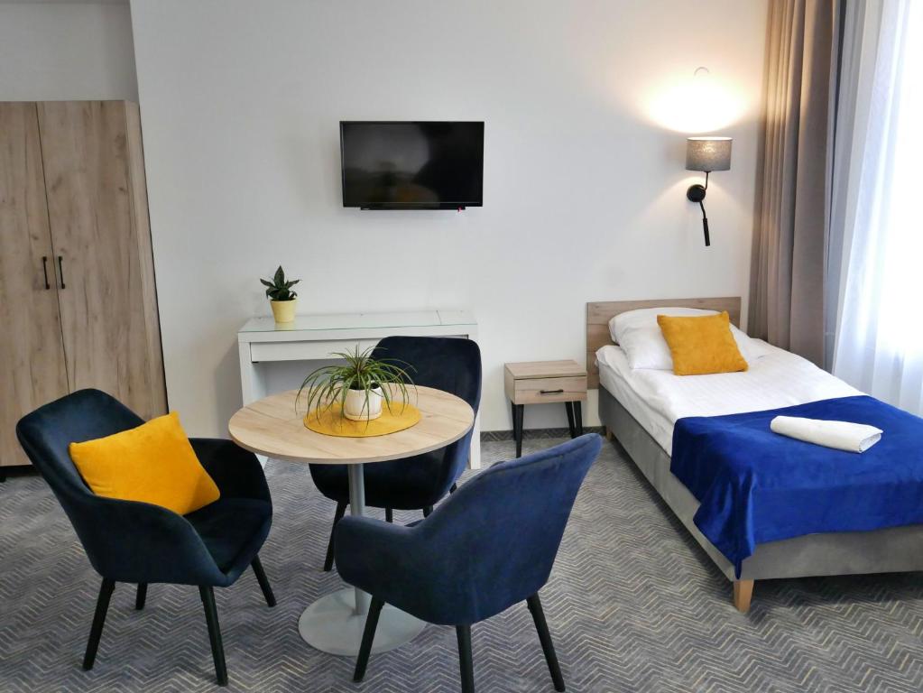 een hotelkamer met een bed en een tafel en stoelen bij Centrum Szkoleniowo-Konferencyjne Społem in Warschau