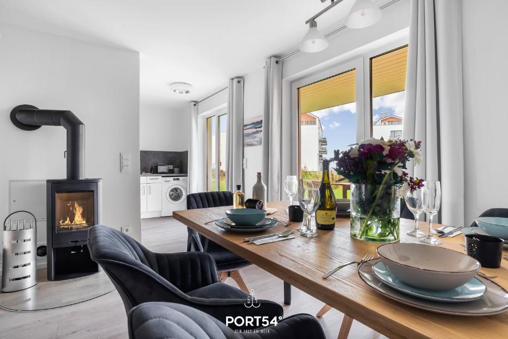 a dining room with a table and chairs and a fireplace at Place to be in Olpenitz