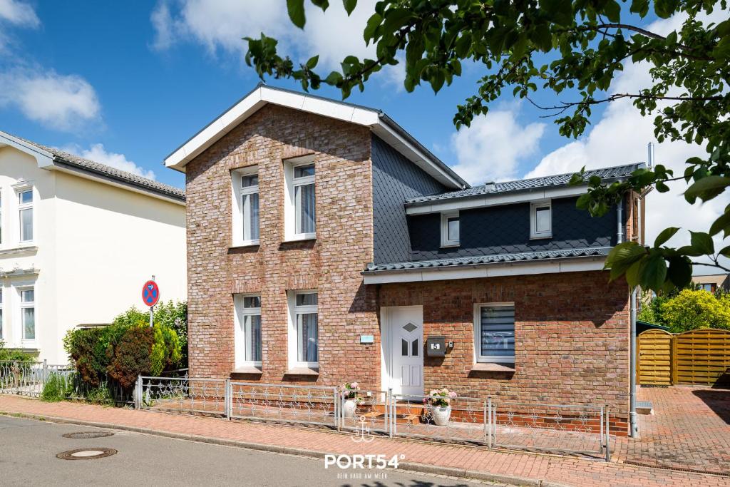 une maison en briques avec un toit noir dans une rue dans l'établissement Villa Nova, à Büsum