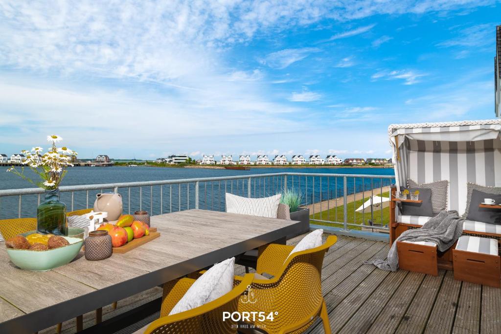 a table on a deck with a view of the water at Meerhaus 18 in Olpenitz