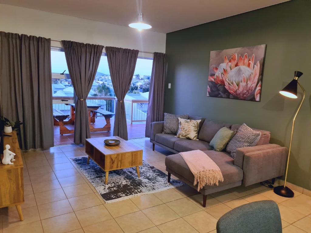 uma sala de estar com um sofá e uma mesa em Weavers Nest 34 em Windhoek